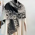 Detalle de bufanda gruesa de leopardo con flecos, combinada con un abrigo beige de invierno - Leopardo Color Block - Negro