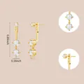 Macro detail of gold zircon earrings showing 0.89 inch length and adjustable closure - Round Triple Stones (e1026) / 14k / One Pair / Gold
