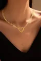 Close-up of golden paperclip chain necklace with a hollow heart pendant on neck - Paperclip Chain Hollow Heart Necklace (x334) / Silver