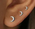 Detailed close-up of three silver crescent moon stud earrings in varying sizes on ear - Moon Style (e1253) / 1 Card with 3 Pieces / Silver