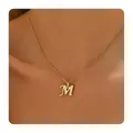 Detail of gold brass necklace with zircon-studded cursive letter M pendant on model - Letter M / 14k