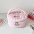 Detailopname van roze pluizige make-uptas met borduursel en dubbele metalen ritsen - Roze