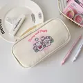 Macro detail of the creamy white canvas pencil case with cute puppy and bunny illustrations - Beige