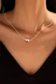 Close-up of elegant gold chain necklace featuring three round white pearls on a model - Three Artificial Pearls Arrangement (x347)