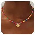 Détail d'un collier de perles multicolores avec pendentif rond doré et lettre E - Lettre E