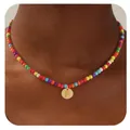 Gros plan du collier de perles colorées avec un pendentif cœur doré et la lettre F - Lettre F
