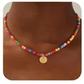 Gros plan d'un collier de perles colorées avec un pendentif cœur doré lettre O - Lettre O