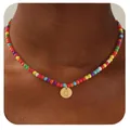 Détail d'un collier de perles colorées avec un pendentif lettre Q doré sur un mannequin - Lettre Q