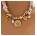 Detail of bohemian silk ribbon necklace with gold charms, leaf, and pearls on a model - Pink Floral Satin Pendant Necklace (x544) / 14k / Pink