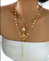 Détail d'un collier multicouche en laiton doré avec perles et pendentif fleur sur modèle - 14k / Or