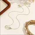 Macro detail of gold infinity necklace pendant with micro-paved cubic zirconia stones - Infinity Symbol Style / 14k / Gold