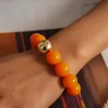 Detailed shot of vibrant orange acrylic beads bracelet with a gold metallic sphere accent - Orange Gold Round Beaded Bracelet
