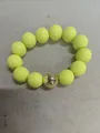 Detail of yellow acrylic beaded bracelet with a central golden metallic bead accent - Lemon Yellow Gold Beaded Bracelet