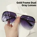 Lunettes aviateur avec monture dorée et verres dégradés gris tenues en main - Monture Dorée Verres Gris Dégradés