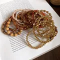 Bohemian acrylic and gold bead stretch bracelet set on vintage book pages background - Gold Brown 18-Piece Bracelet Set