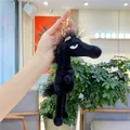 Detail of a black plush pony keychain with golden metal ring and soft fuzzy texture - Approx. 22cm / Black with Gold Buckle