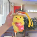 Detail of cute yellow plush duck keychain with a straw hat and red heart crossbody bag - With Red Bag