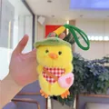 Close-up of cute plush duck keychain with green hat, checkered scarf and small heart bag - With Pink Bag