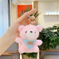 Pink plush teddy bear keychain with a blue polka dot scarf shown in a hand - Hanging Chain / Pink