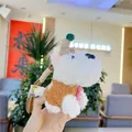 Detail of Westie plush keychain featuring a brown knitted hat and pink floral accent - Brown Clothing / 12cm