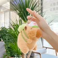 Close-up of plush capybara keychain with white baseball cap and green backpack accessory - Capybara with Backpack and Chain