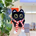 Detailopname van een pluche zwarte kattenhanger met een rood-wit gestreepte sjaal - Zwart / Rode Sjaal / Ketting