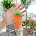 Close-up of cute carrot plush keychain with embroidered smiling face and golden metal clasp - Carrot / Gold Clasp