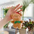 Llavero de oso de peluche marrón con cerezas y cierre dorado sostenido con la mano - Gancho Dorado Oso Marrón
