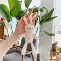 Cute white plush bunny keychain accessory held by hand in a modern living room - Creamy White With Gold Buckle