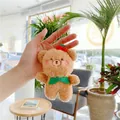 Llavero de osito de peluche marrón con lazo verde y cerezas sostenido en la mano - Cadena Estándar Oso Marrón