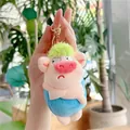 Détail d'un porte-clés cochon en peluche aux cheveux verts et corps bleu pour sacs - Fermoir Doré / Bleu