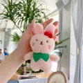 Close-up of a pink plush bunny charm with a red bow and green scarf in a cafe setting - Little Rabbit (Normal Chain) / Pink / Approx. 12cm
