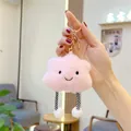 Detailed close-up of a pink plush cloud keychain with embroidered face and stripe legs - Striped Legs Gold Keychain / Pink