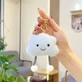 Detail of soft plush cloud keychain with embroidered smile and striped dangling legs - Striped Legs Gold Keychain / 11cm Width x 9cm Height / Blue