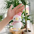 Nahaufnahme vom rosa Pinguin-Plüschanhänger mit Strickmütze, Punkt-Schal und goldenem Karabiner - Goldener Verschluss / Rosa