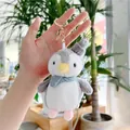 Detail eines Plüsch-Pinguin-Anhängers mit grauer Strickmütze und blauem gepunktetem Schal - Goldener Verschluss / Grau