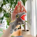 Close-up of a grey dinosaur plush keychain featuring yellow fins and sharp white teeth - Gold Clasp / Gray / 16cm