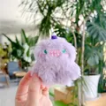 Dettaglio di un ciondolo mostro di peluche viola con morbida pelliccia e occhi ricamati - Con Cappello (Catena Regolare) / Viola