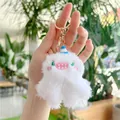 Dettaglio del portachiavi mostro in peluche bianco con ricamo e chiusura a moschettone d'oro - Con Cappello (Fibbia Dorata) / Bianco