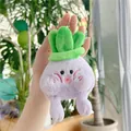 Mano sosteniendo un llavero de peluche de col morada con una hoja verde y un anillo - Cadena Simple / Morado