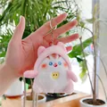 Primer plano de un colgante de gato de peluche con sudadera rosa y llavero metálico - Estilo Cadena Colgante / Rosa