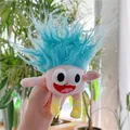 Detailed view of a quirky pink plush doll with fuzzy blue hair and expressive big eyes - Plain Chain / Blue