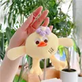Macro shot of yellow plush bird keychain with purple knit flower and silver metal ring - Hanging Chain / Yellow