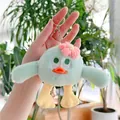 Detailed shot of a plush green bird keychain with a pink flower and silver metal ring - Hanging Chain / Green