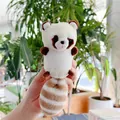 Dettaglio di un portachiavi a forma di procione in peluche morbido tenuto in mano - Stile Catena Sospesa / Bianco Sporco