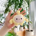 Gros plan d'un charm peluche œuf jaune avec chaussettes rayées tenu près de plantes - Chaîne Simple / Environ 14cm / Jaune