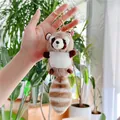 Close-up of soft plush raccoon keychain with a fluffy striped tail and golden ring - Gold Clasp / Brown