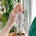 Dettaglio di un portachiavi a forma di squalo in peluche grigio con anello in metallo oro - 13cm / Chiusura Dorata / Grigio