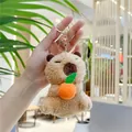 Close-up of plush capybara keychain with orange charm and golden metal clasp - Holding Orange Style (Gold Clasp)