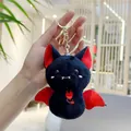 Detailed view of a plush bat keychain featuring red wing accents and a golden metal ring - Black (Gold Buckle)